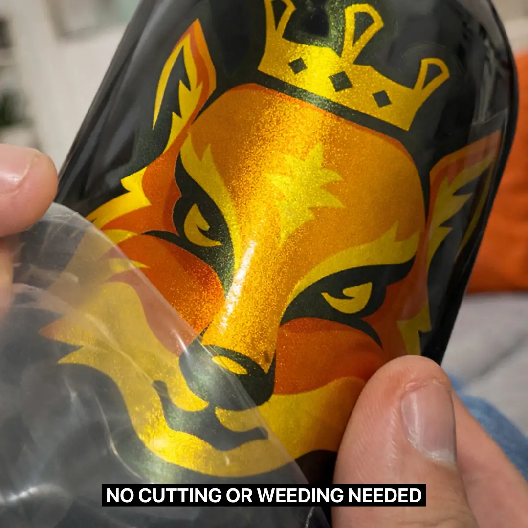 Close-up of fingers half peeling UV Sticker of a gold fox with a crown on a black hand soap bottle.